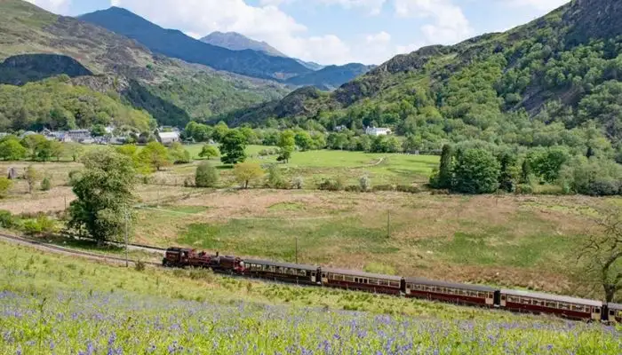 The historic Ffestiniog steam train climbing through the mountainous terrain of Snowdonia National Park.